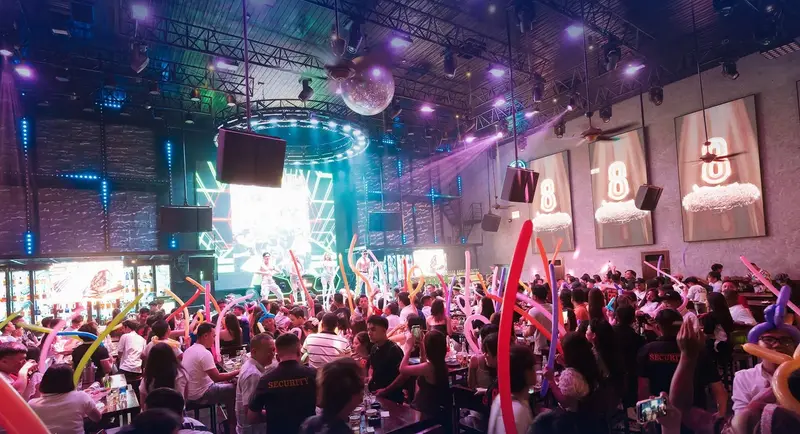 Sảnh chính 88 Beer Garden với ba bảng số 8 phát sáng trên tường, quả cầu gương và khách giơ bóng dài nhiều màu