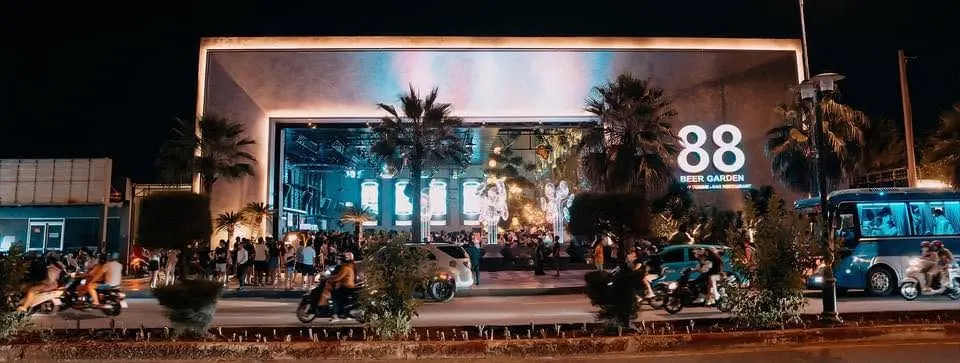 Cổng viền đèn và hàng cọ của 88 Beer Garden về đêm trên đường Thùy Vân